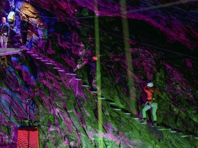 people climbing a ladder staircase underground in zip world caverns