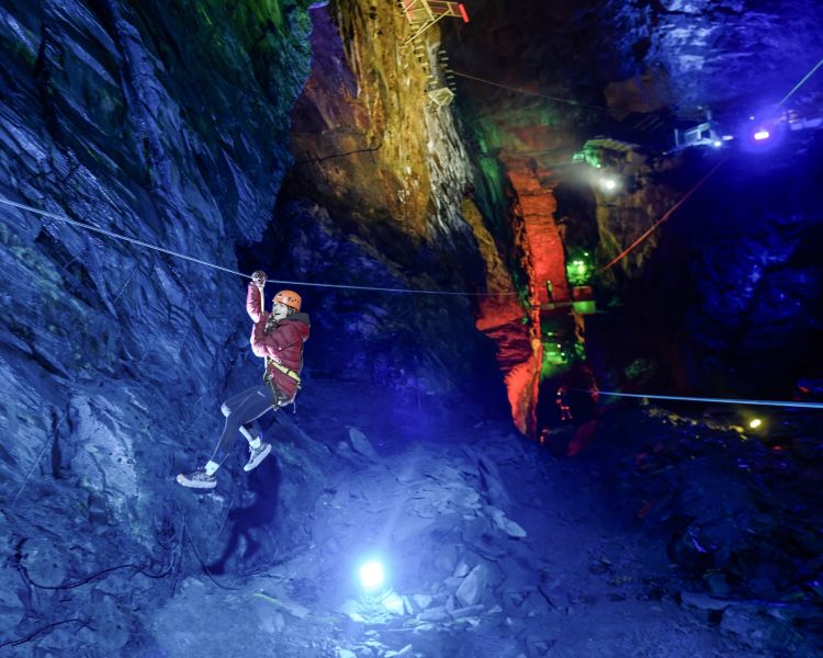 a girl zip lining underground in zip world caverns