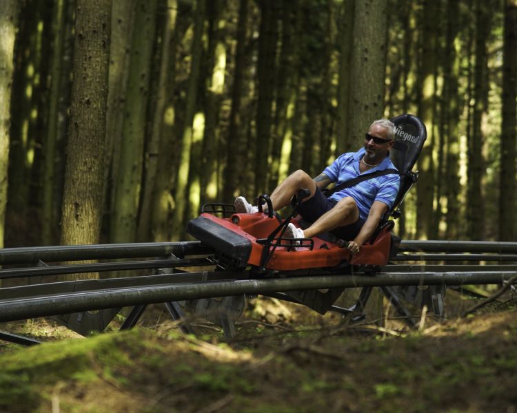 man riding the fforest coaster at zip world in wales