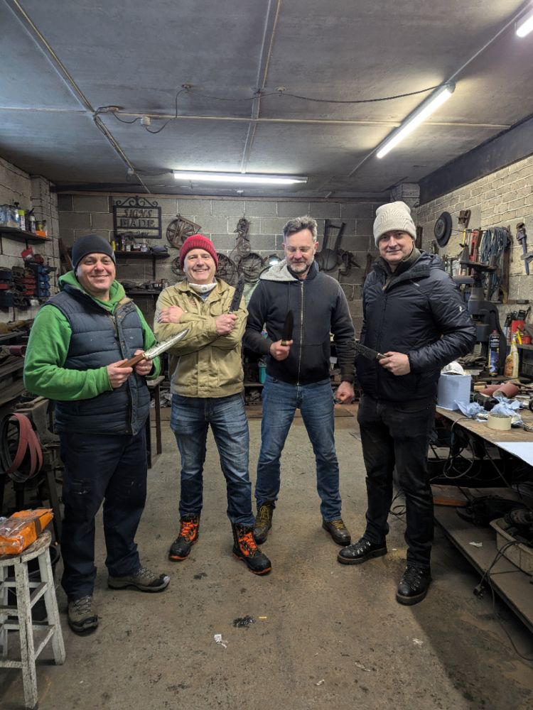 Group of men holding crafted knife
