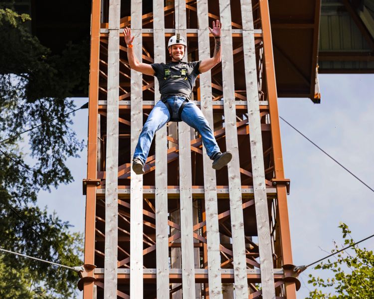man mid air having dropped from the top of zip world plummet