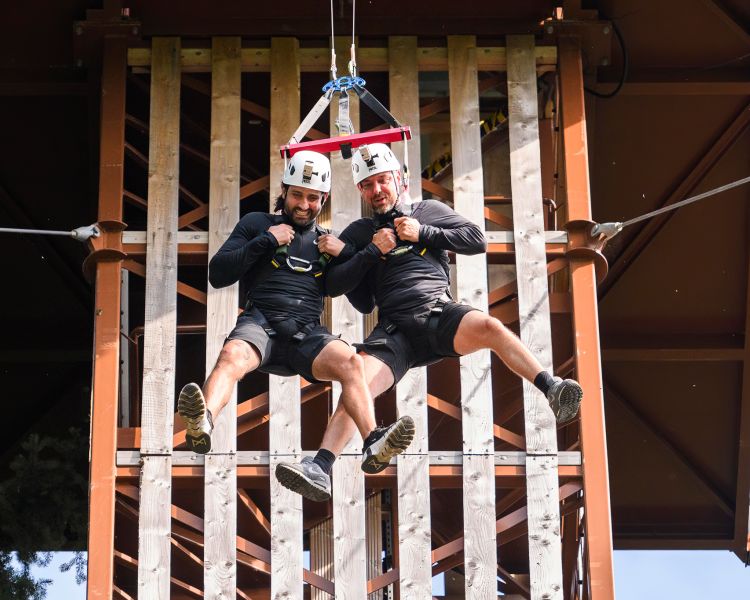 two men mid air as they drop from the top of zip world plummet
