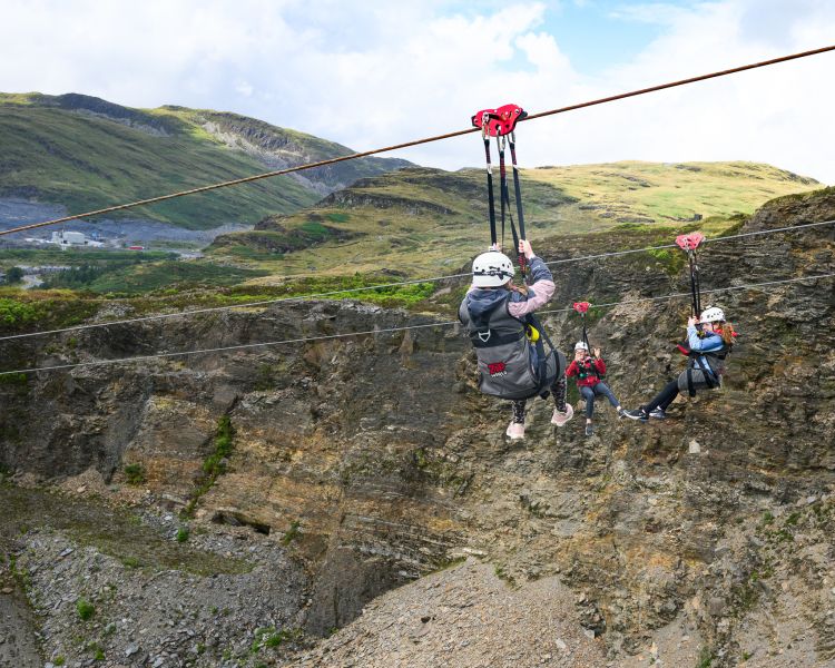 view of people going down the zip lines at zip world titan in wales