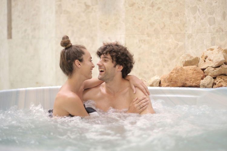 Lady in a hot tub with the sun setting