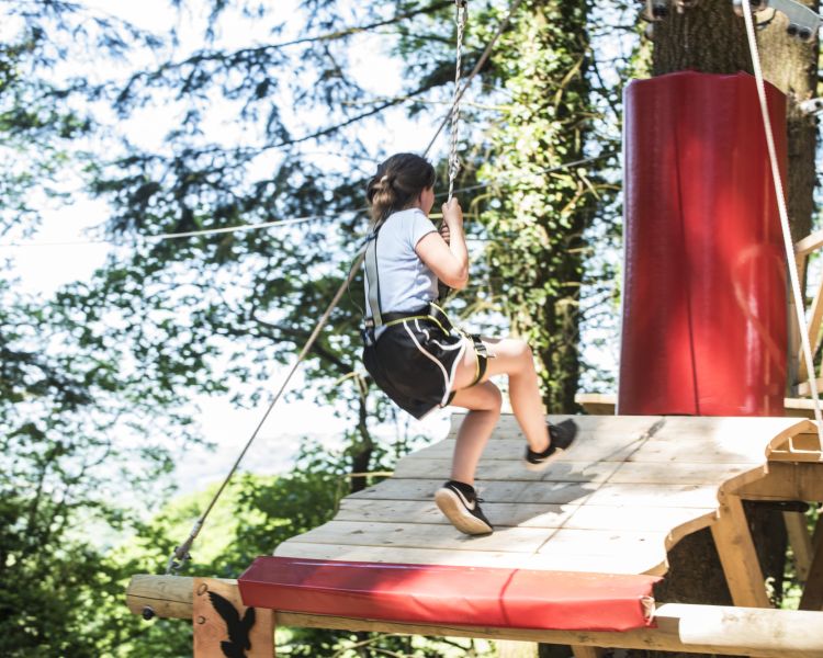 young girl on the zip world tree hoppers course in the trees