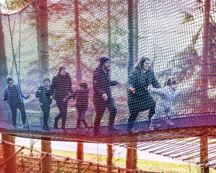 people walking along the nets at zip world treetop nets