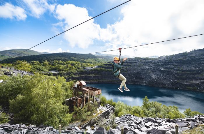 young girl on the zip world quarry flyer zip line going over the quarry