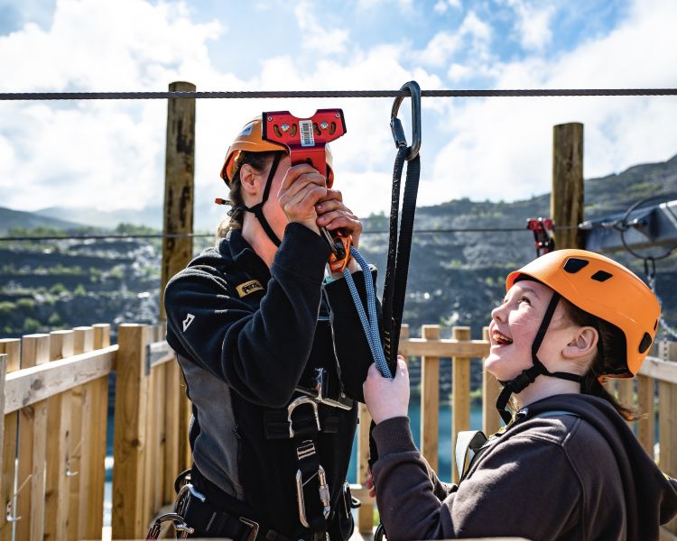 young girl getting ready to go on the zip world quarry flyer zip line