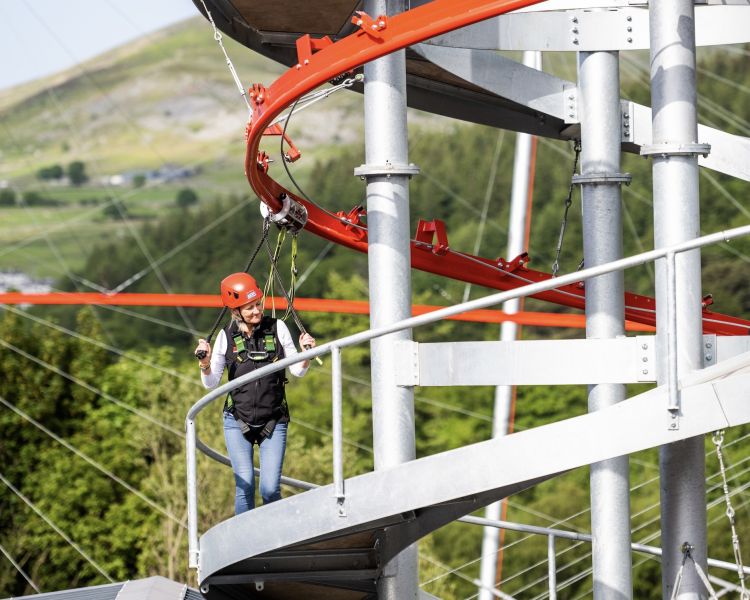 woman climbing up one of the towers on the zip world aero explorer