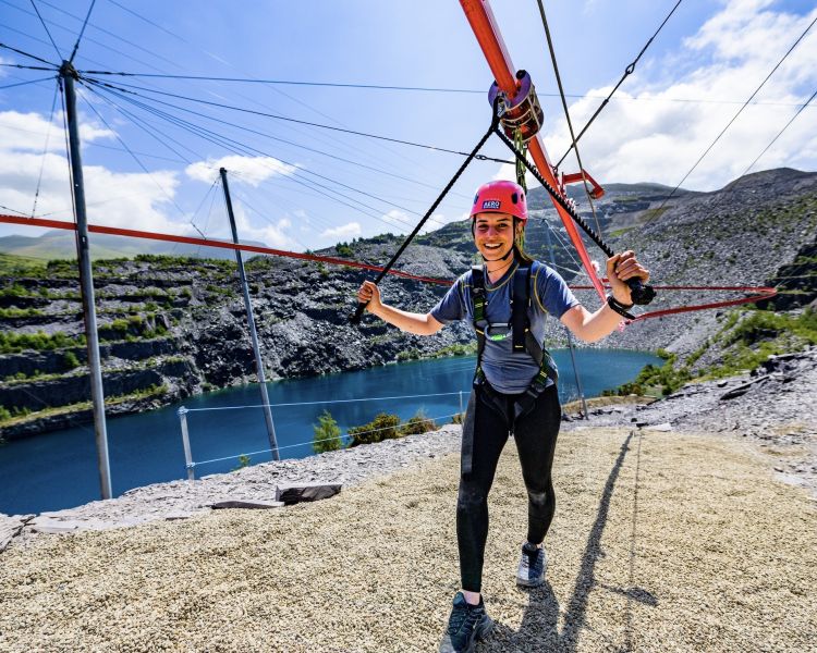 woman having just finished on the zip world aero explorer overlooking the quarry and lake