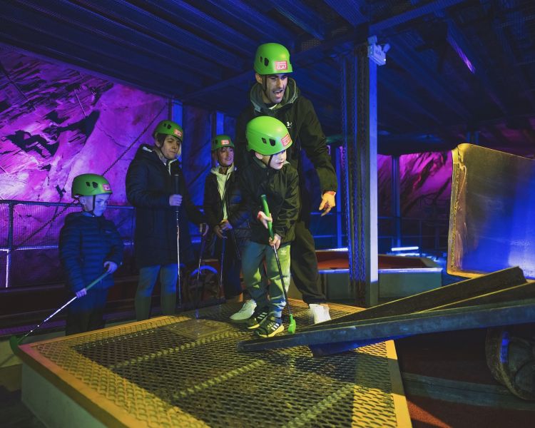 young people playing golf in an old slate mine at zip world underground golf
