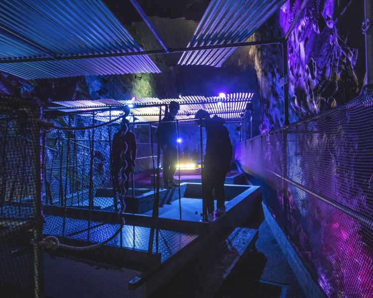 young people playing golf underground in an old slate mine at zip world underground golf