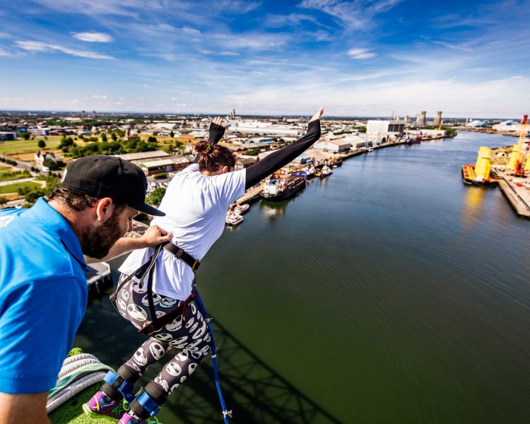 person jumping off the platform on a bungee jump high up over a river