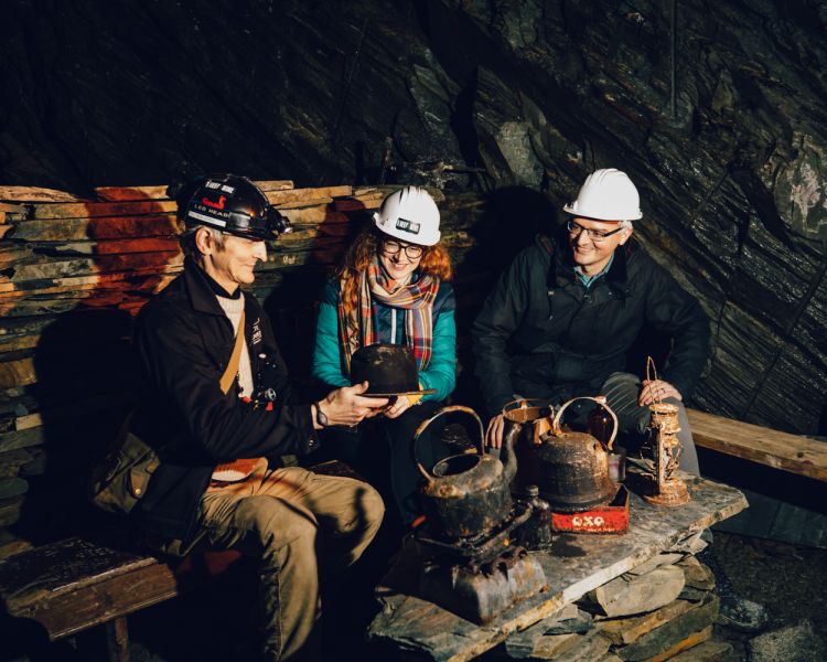 two people looking at equipment used by workers on the zip world llechwedd deep mine tour
