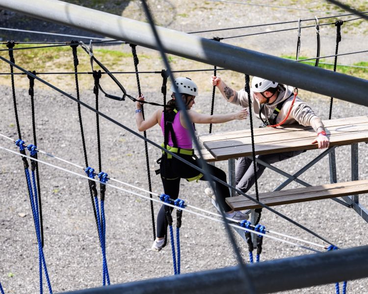 two people navigating the zip world tower climber in south wales