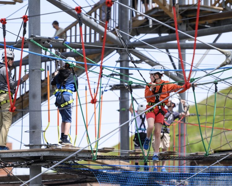 view of people making their way along the zip world tower climber in south wales