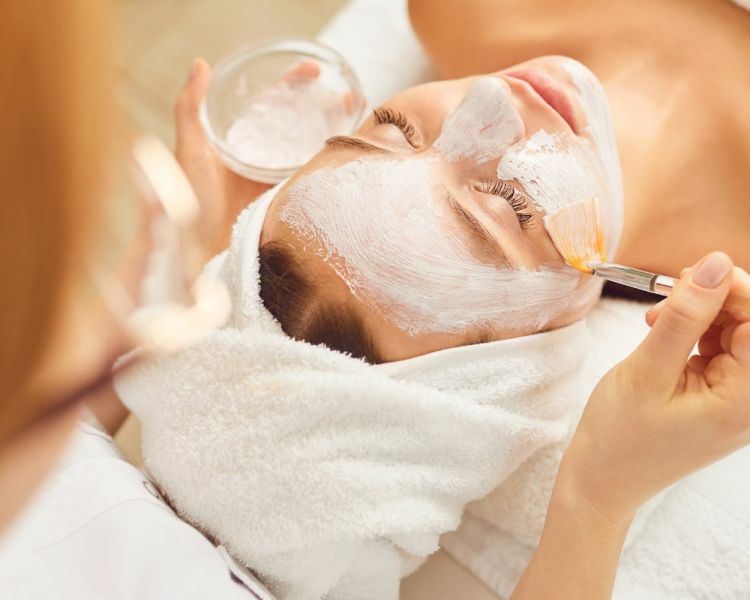 A woman having a face mask applied during a facial