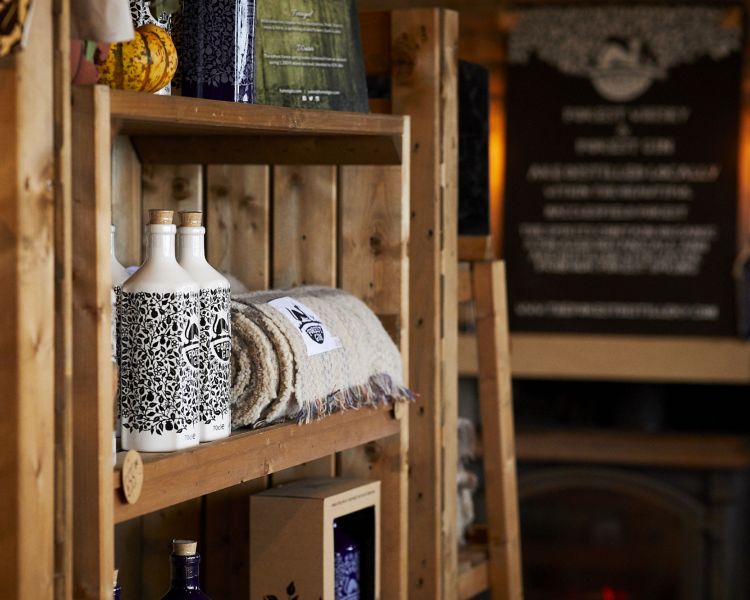 bottles of gin and merchandise that can be purchased on a distillery tour with forest distillery in cheshire