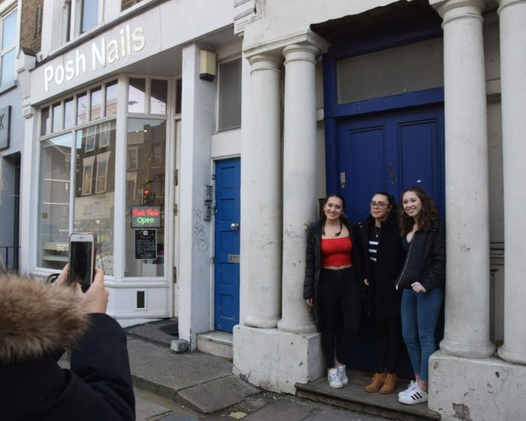 Three girls posing for photo in front of the blue door made famous in the film notting hill