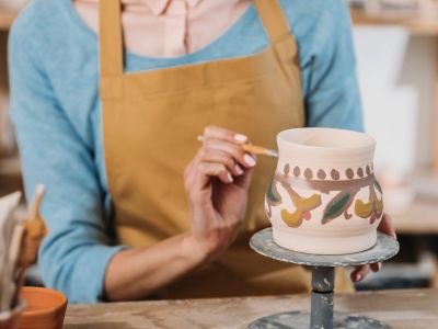 woman painting a piece of pottery on a pottery painting course