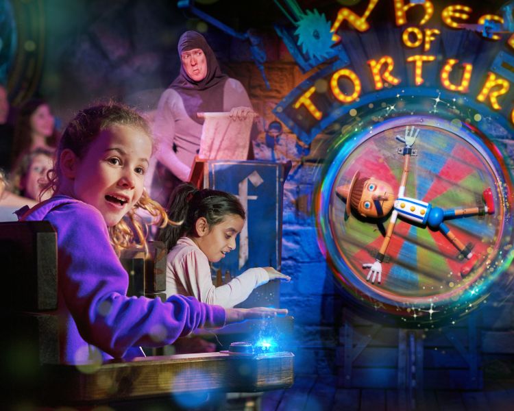 children interacting with the wheel of torture as part of the shrek adventure experience in london