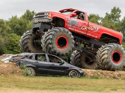 an american monster truck being driven over a car on a monster truck driving experience