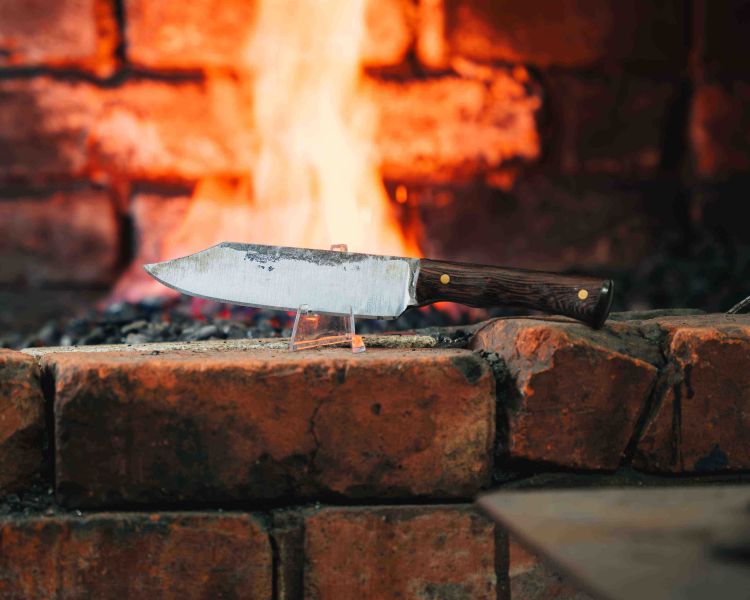 a knife in front of a fire made on a knife making and handling experience