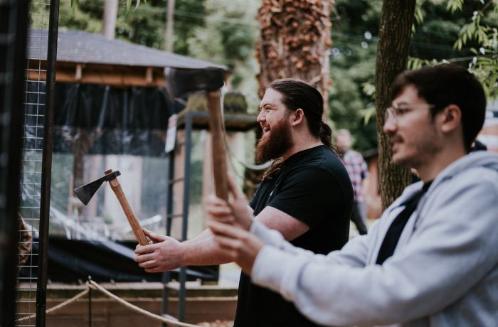 two men holding axes ready to throw them on an axe throwing experience