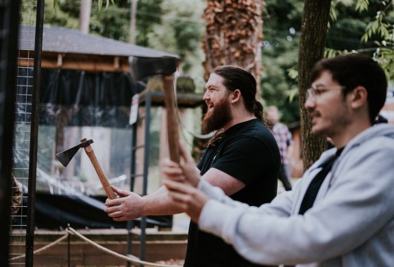 two men holding axes ready to throw them on an axe throwing experience