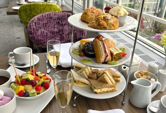 a deluxe afternoon tea with glasses of prosecco laid out on a table