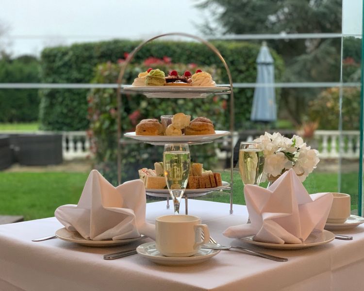 an afternoon tea with glasses of prosecco laid out at a manor house hotel in hertfordshire