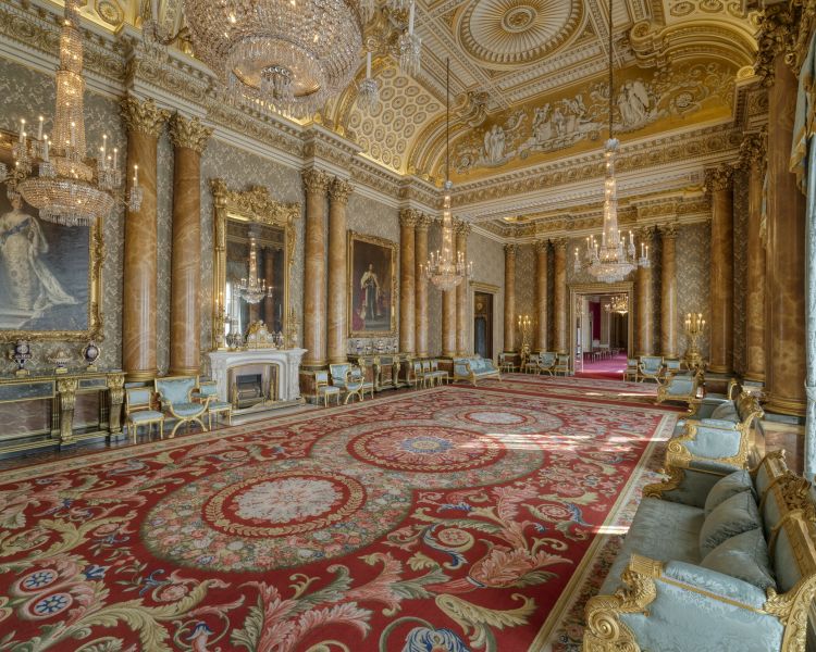 a view into the very grand and ornately decorated blue drawing room at buckingham palace