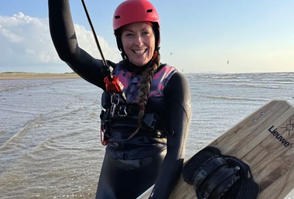 a woman on a beach on a kitesurfing lesson experience