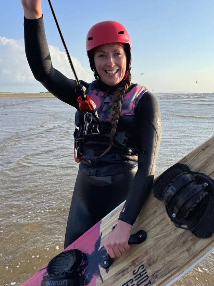 a woman on a beach on a kitesurfing lesson experience