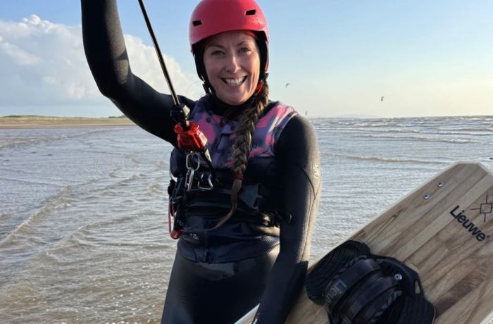 a woman on a beach on a kitesurfing lesson experience