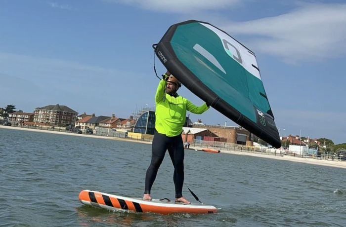 man wingsurfing on the water on a learn to wingsurf experience