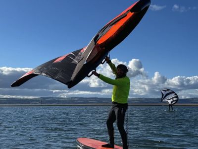 man wingsurfing on the water on a learn to wingsurf experience