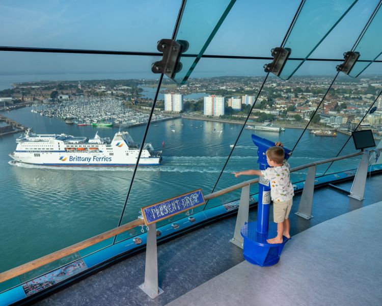 A child watches a boat sail by