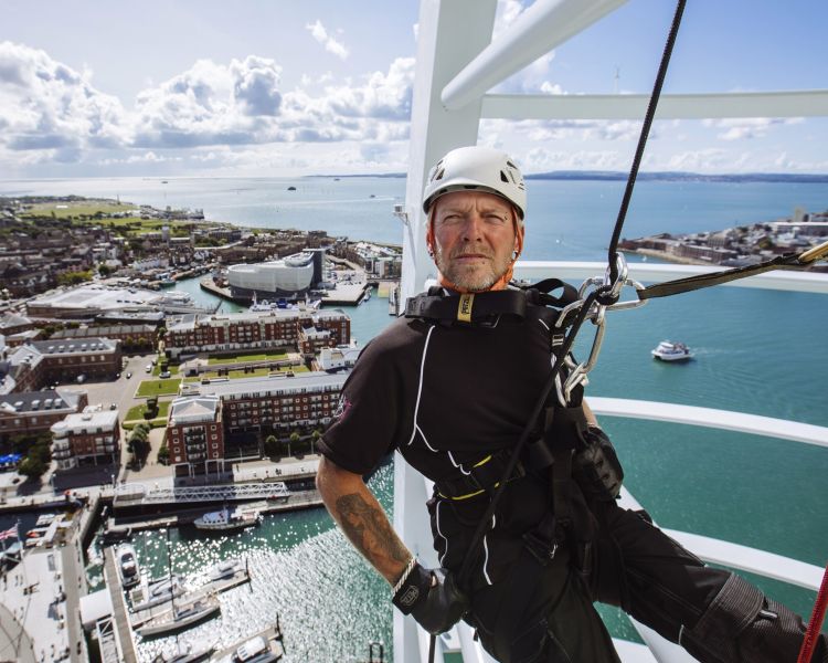 An instructor abseiling down Spinnaker Tower