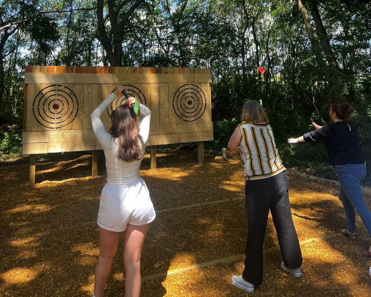 two girls throwing axes at targets on an adventure experience