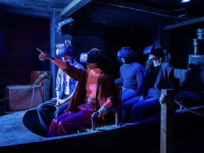people wearing vr headsets sitting in a boat on the war of the worlds immersive experience