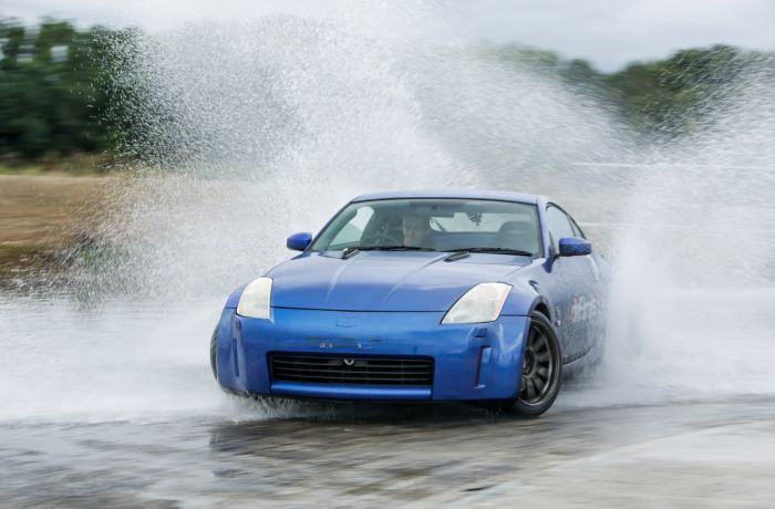 blue sports car drifting through water