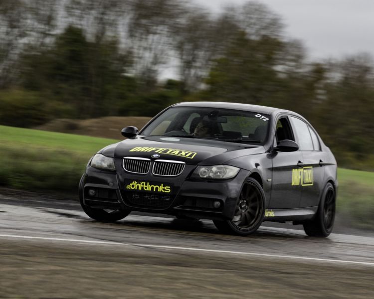 a black bmw on a hemel hemstead race track as part of a drifting battle experience