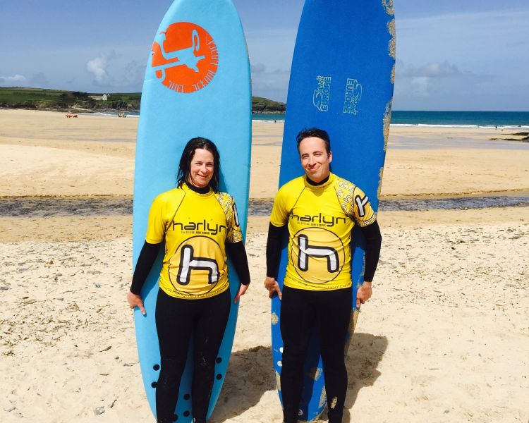 Two people standing in front of surf boards