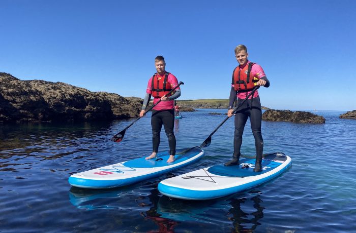 2 men paddleboarding in the sea