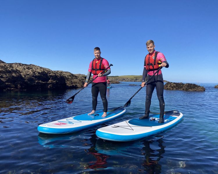 2 men paddleboarding in the sea
