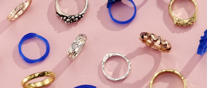 a selection of gold and silver rings and their wax ring models shown as examples of what you can make on a ring making experience