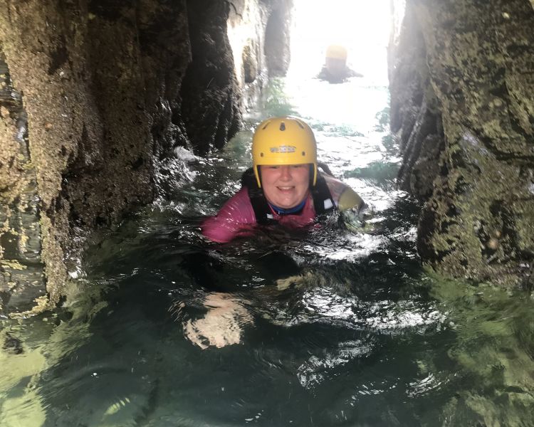 Woman swimming through a cave