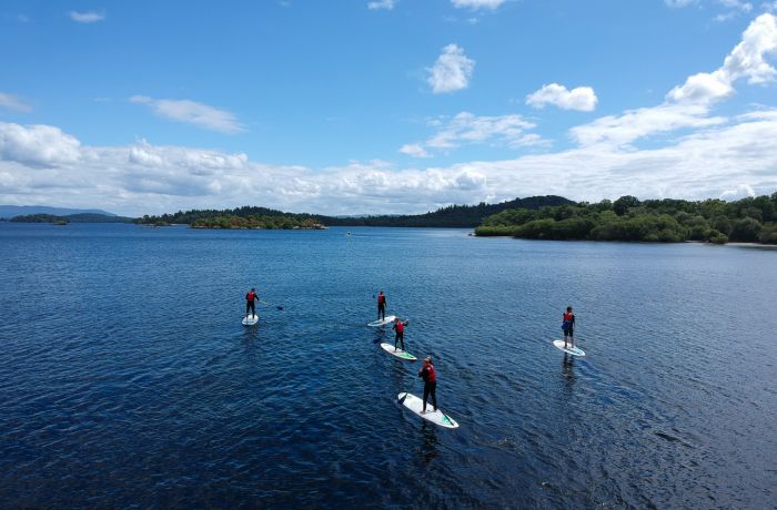 group of people paddle boarding on a lake