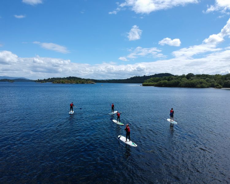group of people paddle boarding on a lake